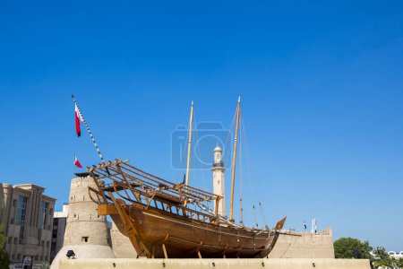 Foto de Pequeños botes tradicionales de remo de madera - abras, con paredes de Al Fahidi Old Fort en el fondo, distrito histórico de Al Fahidi, Dubai, Emiratos Árabes Unidos. - Imagen libre de derechos