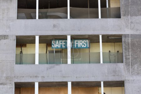 Foto de Edificio antiguo dedicado a los trabajadores del sector de la construcción en Dubai con cartel "seguridad primero" - Imagen libre de derechos