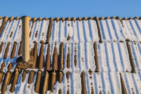 Téléchargez les photos : Melting snow on an old slate roof - en image libre de droit