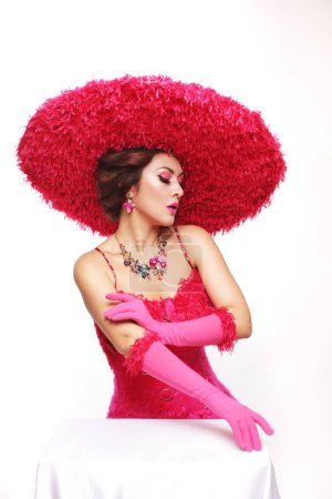 Beautiful lady in pink outfit big feather hat and gloves