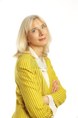Photo for Beautiful blond lady in her 50s wearing yellow jacket posing over white background - Royalty Free Image