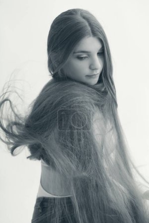 Thoughtful young woman with extra long hair monochrome portrait