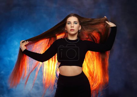 Girl with natural grown own hair over blue background with orange backlight
