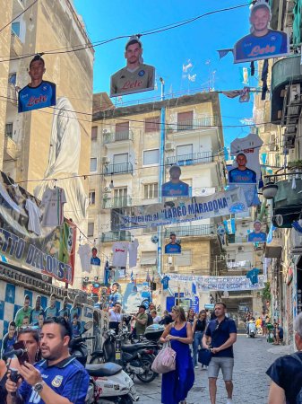 Foto de Nápoles, Italia, 27 de septiembre de 2023: El barrio de Quartieri Spagnoli en Nápoles con un mural de Diego Armando Maradona y un gran número de tiendas relacionadas con el fútbol y el club Napoli. - Imagen libre de derechos