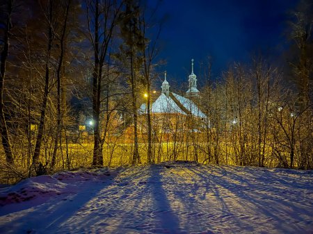 Old wooden church dedicated to St. Trinity Church in Koszecin, Poland. View at night.