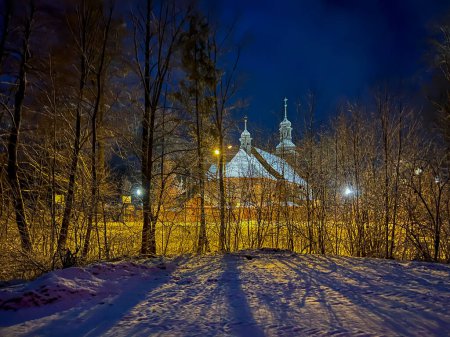 Old wooden church dedicated to St. Trinity Church in Koszecin, Poland. View at night.