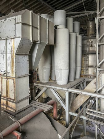 Exhaust gas ducts with a through dust collector and a cyclone battery and an industrial chimney, part inside the building.