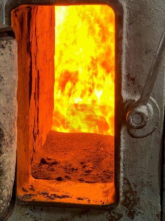 Feuer in der Brennkammer eines Kohleheizkessels, sichtbar durch das Fenster.