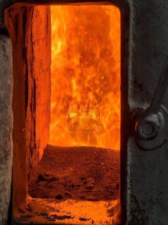 Feuer in der Brennkammer eines Kohleheizkessels, sichtbar durch das Fenster.