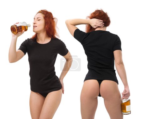 Photo for Photo of a young beautiful redhead woman with blank black shirt and black underwear, drinking whisky from a bottle. Isolated over white background and ready for your design or artwork. - Royalty Free Image