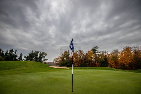 golf flag on a green in the fall 