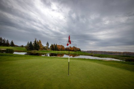 golf flag on a green in the fall 