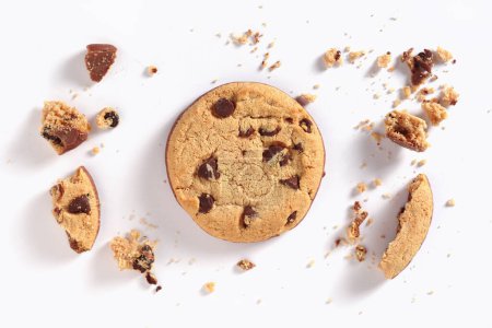 Chocolate chip cookies and pieces with crumbs on a white background. Top view