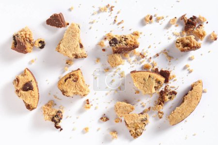 Téléchargez les photos : Morceaux de biscuits aux pépites de chocolat avec miettes sur fond blanc. Vue du dessus - en image libre de droit