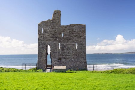 Téléchargez les photos : Ruines du château de Ballybunion debout sur la rive de l'océan dans le comté de Kerry, Irlande. Une des attractions de Wild Atlantic Way. - en image libre de droit