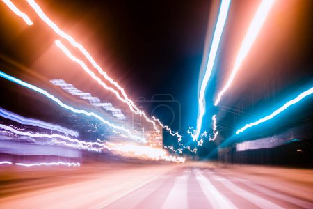 Photo for Trails of neon urban lights on city street, motion blur created by long exposure photography - Royalty Free Image