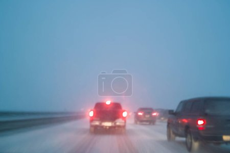 Fahren bei schlechtem Wetter mit Schnee auf der Nachtautobahn, Langzeitbelichtung in der Kamera Bewegungsunschärfe