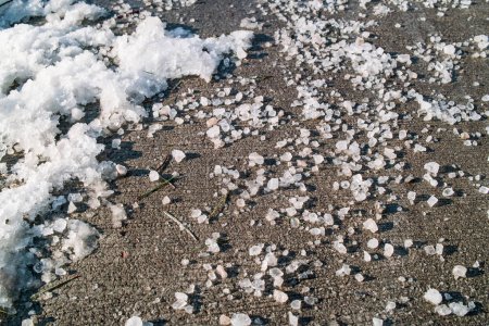 Gros plan sur le sel gemme sur le trottoir appliqué sur la glace fondante et la neige