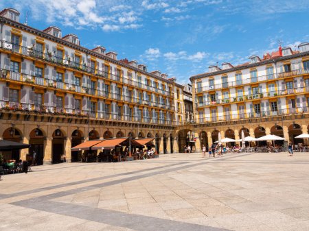 Photo for View of the Plaza de la Constitucion (Constitution Square) in heart of San Sebastian Old Town, Spain. Rectangular shape and surrounded by 4-storey arcaded buildings. Blue sky background. - Royalty Free Image