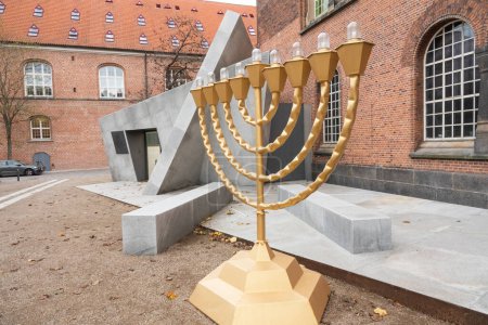 Photo for Temple Menorah by The Danish Jewish Museum entrance in Copenhagen as seen from the garden of the Danish Royal Library. Architect is Daniel Libeskind.  Copenhagen, Denmark - November 21, 2023. - Royalty Free Image