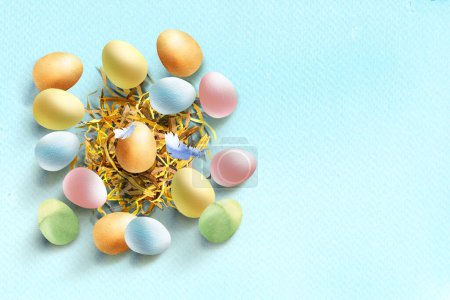 Photo for Colorful easter eggs in the nest with feathers, pastel color. Happy Easter concept, horizontal banner, poster, template header, copy space. Hand drawn watercolor illustration on blue background - Royalty Free Image