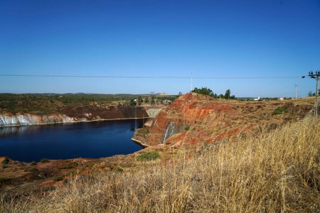 Foto de Lago de estanque contaminado de un viejo paisaje minero abandonado para la minería de cobre con tierra roja - Imagen libre de derechos