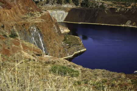 Foto de Lago de estanque contaminado de un viejo paisaje minero abandonado para la minería de cobre con tierra roja - Imagen libre de derechos
