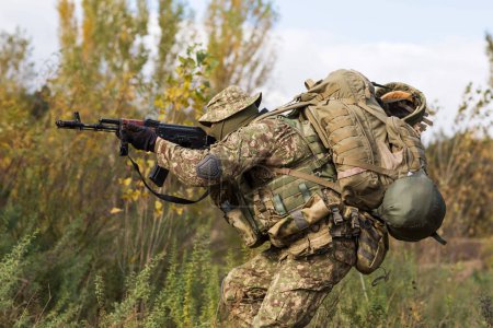 Téléchargez les photos : Soldat ukrainien en uniforme militaire et équipement complet sur le champ de bataille pendant la guerre - en image libre de droit