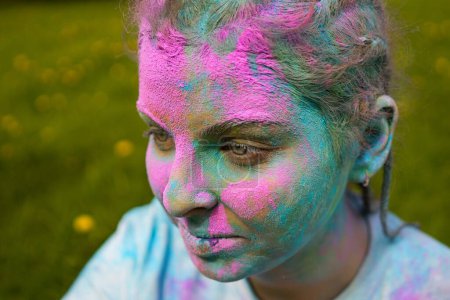 Foto de Retrato de mujer europea feliz celebrando Holi con colores en polvo o gulal. Concepto de festival indio Holi. - Imagen libre de derechos