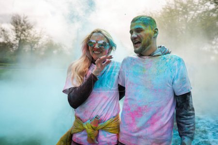 Téléchargez les photos : Portrait d'un heureux couple européen célébrant Holi avec des couleurs poudre ou gulal. Concept de festival indien Holi - en image libre de droit
