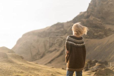 Téléchargez les photos : Une fille en vêtements de mode pose sur un fond de montagnes - en image libre de droit