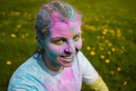Foto de Retrato de mujer europea feliz celebrando Holi con colores en polvo o gulal. Concepto de festival indio Holi. - Imagen libre de derechos