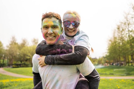 Téléchargez les photos : Portrait d'un heureux couple européen célébrant Holi avec des couleurs poudre ou gulal. Concept de festival indien Holi - en image libre de droit