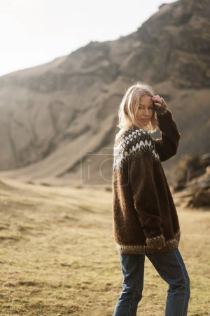 Téléchargez les photos : Une fille en vêtements de mode pose sur un fond de montagnes - en image libre de droit