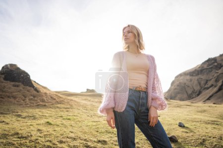 Téléchargez les photos : Fille de la mode dans une veste violette pose contre dans les montagnes en Islande - en image libre de droit