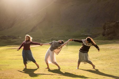 Téléchargez les photos : Les filles dansent dans une robe colorée légère au coucher du soleil en Islande - en image libre de droit