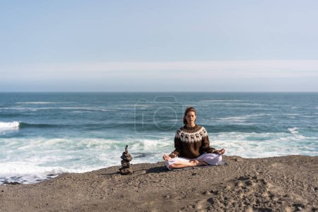 Téléchargez les photos : Une fille fait du yoga sur l'océan en Islande - en image libre de droit