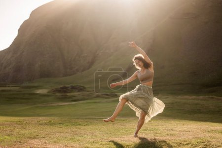 Téléchargez les photos : Fille dansant dans une robe légère au coucher du soleil en Islande - en image libre de droit
