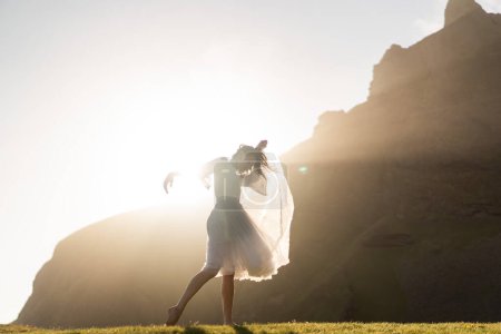 Téléchargez les photos : Fille dansant en robe au coucher du soleil en Islande - en image libre de droit