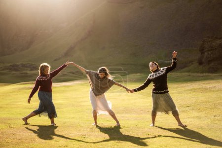 Téléchargez les photos : Les filles dansent dans une robe colorée légère au coucher du soleil en Islande - en image libre de droit