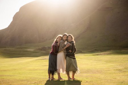 Foto de Un grupo de niñas turistas en coloridos suéteres islandeses nacionales al atardecer en Islandia - Imagen libre de derechos