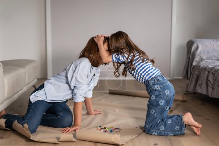 Photo for Mother and daughter at home are engaged in drawing and communicating with each other - Royalty Free Image