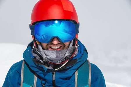Photo for Close up of the ski goggles of a man with the reflection of snowed mountains. A mountain range reflected in the ski mask. Portrait of man at the ski resort on the background of mountains and sky. - Royalty Free Image