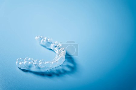 Fermer aligneurs invisibles sur le fond bleu avec espace de copie. Appareils dentaires en plastique pour redresser les dents.