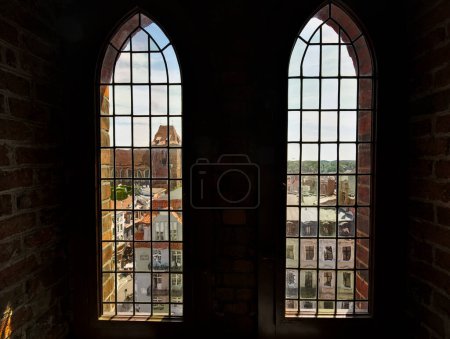 Téléchargez les photos : Vue à travers les hautes fenêtres gothiques de la tour de la mairie sur la vieille ville de Torun, Pologne - en image libre de droit