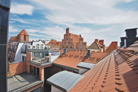 Foto de Techos y edificios de ladrillo en el casco antiguo de Torun en Polonia. La vista desde la terraza en el soleado día de verano. - Imagen libre de derechos