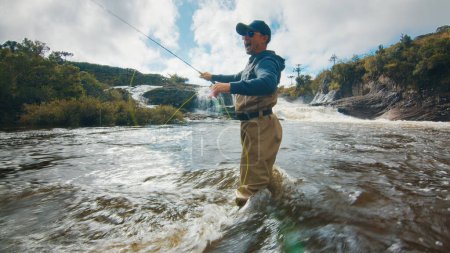 Photo for Fly fishing. Fisherman in waders fishing on the rapid river - Royalty Free Image
