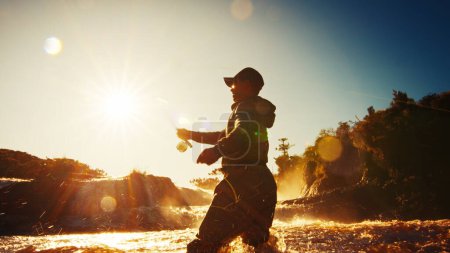 Foto de Pesca con mosca. Pescador en vadeadores pescando en el río rápido - Imagen libre de derechos