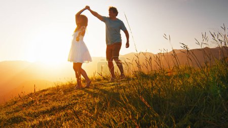Foto de Hombre y mujer bailan en el prado de verano con hierba al amanecer - Imagen libre de derechos