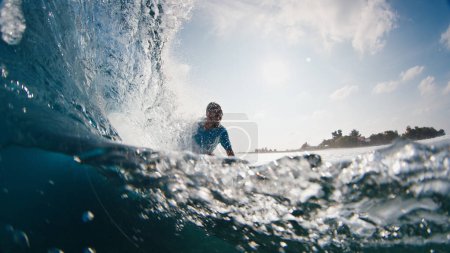 Photo for Surfer rides the wave. Young man surfs the ocean wave in the Maldives, splitted above and underwater view - Royalty Free Image